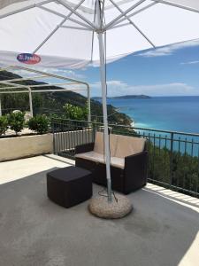 a patio with an umbrella and a chair under a table at Residenze Cutrì Casa Vacanze Cilento by ElodeaGroup in Pisciotta +51 photos