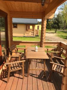 un tavolo e sedie in legno su una terrazza di legno di Borowiak a Szteklin
