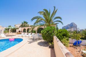 a villa with a swimming pool and a palm tree at Villa Maya by Abahana Villas in Calpe