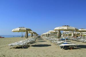 a row of chairs and umbrellas on a beach at Villa sul mare Marinagri Resort in Policoro