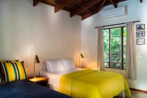 a bedroom with two beds and a window at The Sunset Shack in Nosara