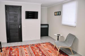 Zimmer mit einem Stuhl, einem Tisch und einem TV in der Unterkunft 77/5 in Chişinău