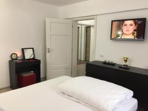a bedroom with a white bed and a tv on the wall at Luxury Apartment in Galaţi