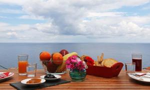 a table with a plate of food and a bowl of fruit at Anemi Apartments in Armenistis