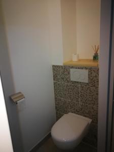 a small bathroom with a toilet and a shelf at lupin in Rochefort