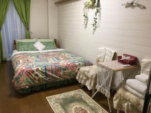 a bedroom with a bed and a chair and a table at Otsu - House / Vacation STAY 2968 in Otsu