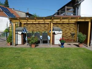 a pergola with chairs and a table in a yard at Gästehaus Labahn in Ueckeritz