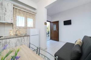 uma sala de estar com um sofá e uma cozinha em Sevastiani’s Apartments em Skala Kallirachis