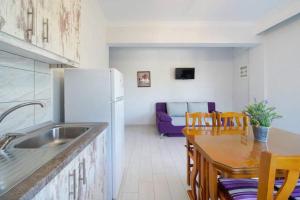 uma cozinha com um frigorífico e uma mesa com cadeiras em Sevastiani’s Apartments em Skala Kallirachis