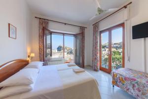 a hotel room with two beds and a window at Hotel Europa in Ischia