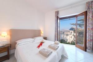 a bedroom with a bed and a large window at Hotel Europa in Ischia
