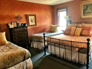 a bedroom with two beds and a dresser at Historic Skagway Inn in Skagway