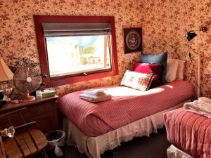 A bed or beds in a room at Historic Skagway Inn