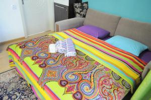 a bed with a colorful blanket on top of it at Baku Seafront Apartment in Baku