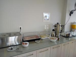 a kitchen counter with several trays of food on it at Katerina Lefkada in Vasiliki