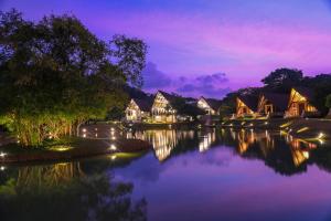 a view of a river with houses at night at Liyya Water Villas in Dambulla