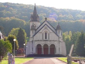 a large white church with a tower on a hill at Chalet de campagne in Sancey-le-Grand