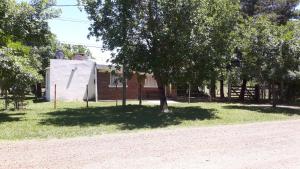 a building in a park with trees in front of it at Casa Don Francisco in Termas del Daymán