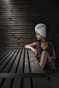a woman sitting on a bench with a towel on her head at Lamasu RioVerde - Lago di Garda in San Felice del Benaco