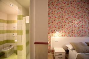 a bedroom with a bed and a bathroom with a sink at Hotel Bencidormi in Florence