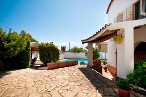 a backyard with a pool and a house at Hotel L'Aragosta in La Caletta