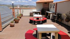 a balcony with tables and benches on a roof at Cittadella Hostal in Sucre