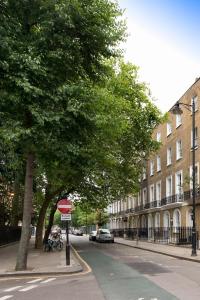 una calle con un árbol y una señal de no entrar en Angus Hotel, en Londres