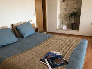 a bedroom with a bed with a book on it at Guest House Dijana in Korčula
