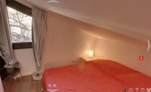 Un dormitorio con una cama roja y una ventana. en Appartement 5 pièces à ISOLA 2000, en Isola 2000