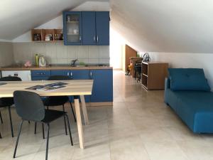 a kitchen and living room with a table and a blue couch at Guest House Dijana in Korčula