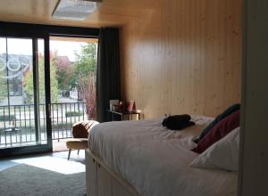 1 dormitorio con 1 cama grande y balcón en ROOTS Tiny House en Tilburg