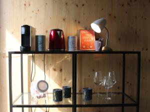 een plank met kopjes, een lamp en wijnglazen bij ROOTS Tiny House in Tilburg