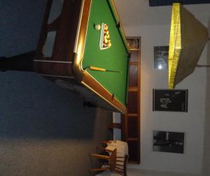 a pool table hanging from a wall next to chairs at Alpenhotel Beslhof in Ramsau