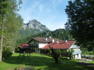 une maison avec une montagne en arrière-plan dans l'établissement Alpenhotel Beslhof, à Ramsau bei Berchtesgaden