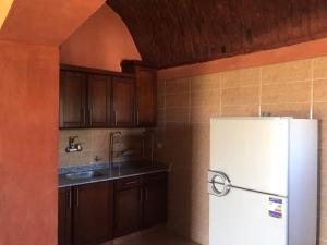 a kitchen with a white refrigerator and wooden cabinets at Zaytona Lake View in Fayoum Center