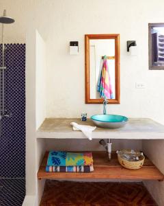 a bathroom with a sink and a mirror at Jakes Hotel in Treasure Beach