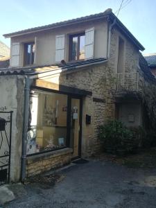 een oud stenen huis met een raam bij Appart impasse du sentiment in Montignac