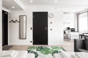 a living room with a black door and a kitchen at Hiisi Homes Helsinki Haaga in Helsinki