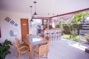 a kitchen and dining room with a table and chairs at Ubatuba Ecologic Pousada in Ubatuba