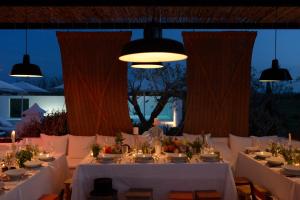 uma mesa de jantar com toalhas de mesa brancas e velas em Pensão Agrícola em Cabanas de Tavira