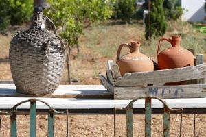 una mesa con tres jarrones en una caja de madera en Pensão Agrícola, en Cabanas de Tavira