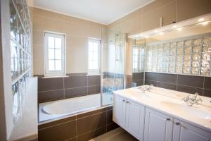 een badkamer met 2 wastafels, een bad en een douche bij Villa Lena in Pakoštane