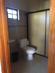 a bathroom with a toilet and a glass door at Hostal Aquismon in Aquismón