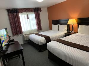 a hotel room with two beds and a television at Lake Country Inn in Winfield