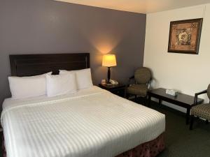 a hotel room with a bed and two chairs at Lake Country Inn in Winfield