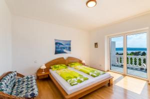 um quarto com uma cama grande e uma varanda em One-Bedroom Apartment in Crikvenica IX em Sopaljska