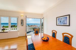 a dining room with a table and chairs and a balcony at One-Bedroom Apartment in Crikvenica IX in Sopaljska