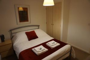 a bedroom with a bed with two towels on it at Brook Apartment in Bristol