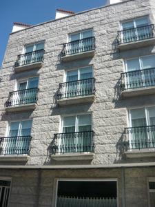 un edificio con balcones en un lateral en Hotel Grove, en O Grove