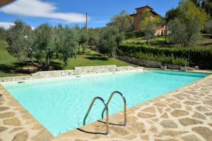 ein großer Pool in einem Garten mit Bäumen in der Unterkunft la Torretta di Villa Borri Chianti Classico in San Casciano in Val di Pesa